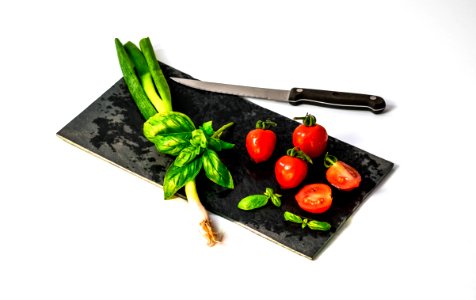 slice of tomato on board beside knife photo