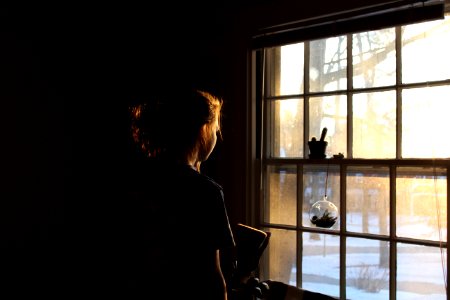 woman in room facing window photo