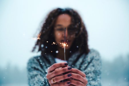 selective focus photography of person holding lighted sparkler photo