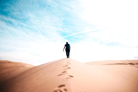man walking on desert photo