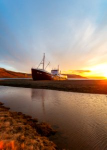 white and brown ship on seashore under sunrise