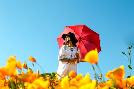woman in white dress under red umbrella