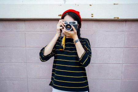 woman holding DSLR camera while taking picture photo