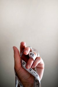 person's left hand wrapped by tape measure photo