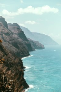 rocky mountains next to ocean water photo