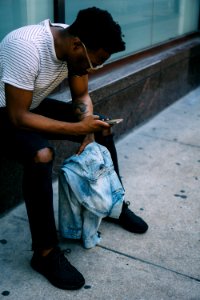 man sitting while using phone photo