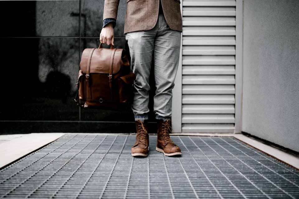 person holding brown leather bag