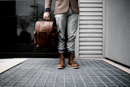 person holding brown leather bag