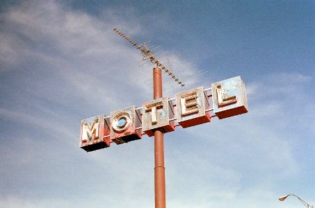 brown metal Motel road sign at daytime photo