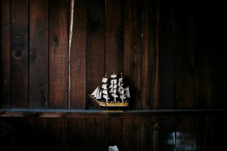 black, brown, and white galleon ship scale model on brown wooden shelf photo