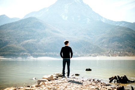 man standing on front of lake at daytime photo