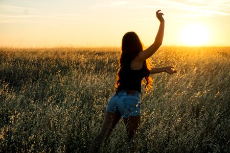 woman dancing at green grass field during sunset photo
