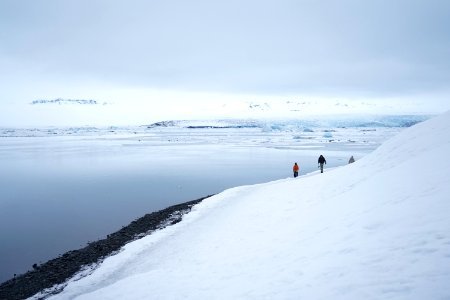 two people walking on snow covered ground