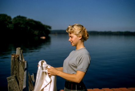 woman holding white textile standing beside body of water photo
