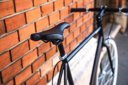 black rigid bike leaning on brown brick wall