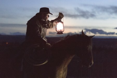 man riding horse holding lantern photo