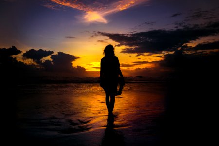 silhouette of woman standing on seashore photo