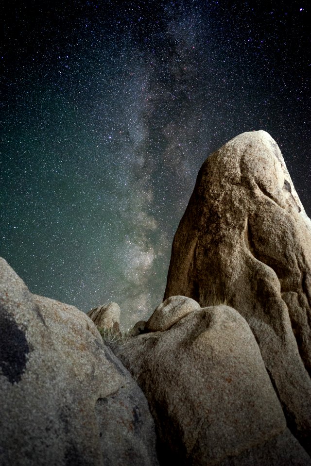 brown rock formations under starry night