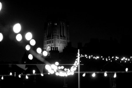 grayscale photography of stringlights and tower photo