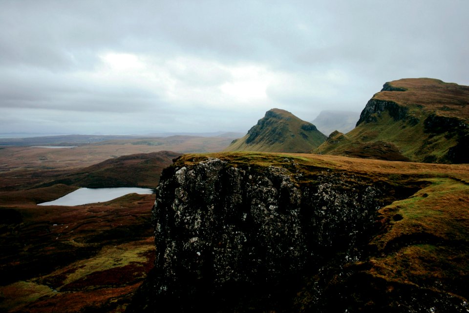 rock cliff under gray clouds
