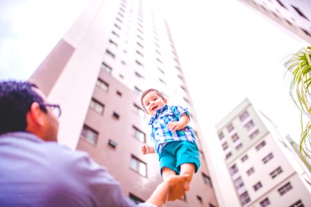 shallow focus photography of father holding his son in right hand photo