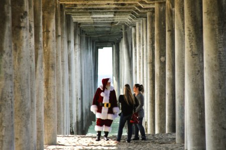 Santa Claus talking to woman near concrete post photo