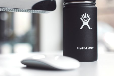 white Apple Magic Mouse beside Hydro Flask jar photo