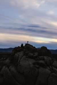 person standing on gray rock formation during daytime photo