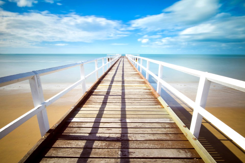 brown and white wooden dock under white clouds