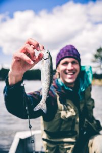 depth photography of man holding fish photo