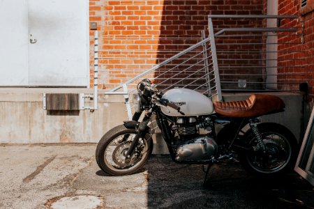 white and brown cruiser motorcycle beside gray steel railings photo