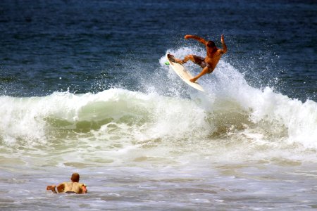man surfboarding on ocean wave during daytime photo