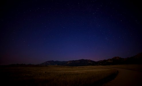 green grass field near mountain at night time photo
