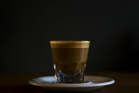 coffee filled rock glass on saucer photo