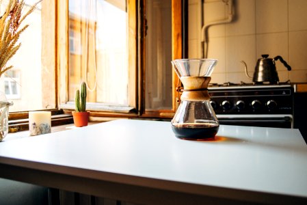 almost empty black liquid inside glass on white table photo