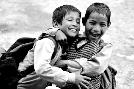 grayscale photography of two boys hugging while laughing photo