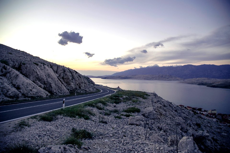 gray concrete road near body of water during daytime