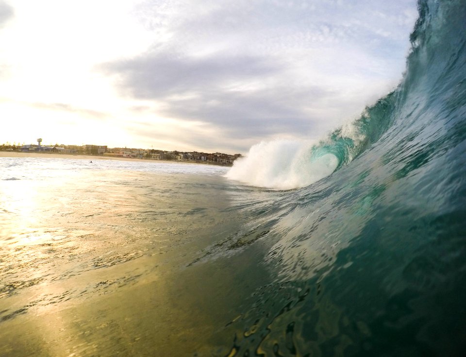 A large wave coming in during the early evening sunset.
