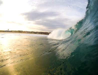 A large wave coming in during the early evening sunset.