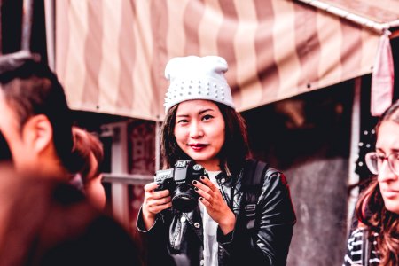 woman in black leather jacket holding DSLR camera photo