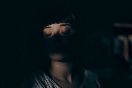 woman sitting inside dark room photo