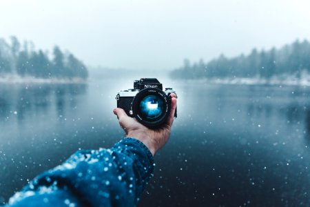 person taking selfie using Nikon DSLR camera photo