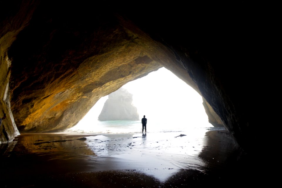 photography of person standing in cove