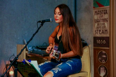 woman playing guitar while singing
