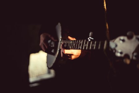 person playing banjo inside dark room photo