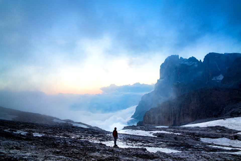 person standing near the cliff of the mountain
