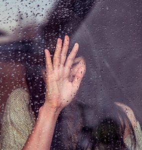 woman touch rainy glass photo