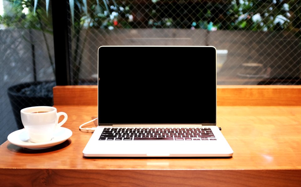 laptop computer beside coffee mug photo