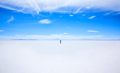person walking of sand covered field during daytime photo