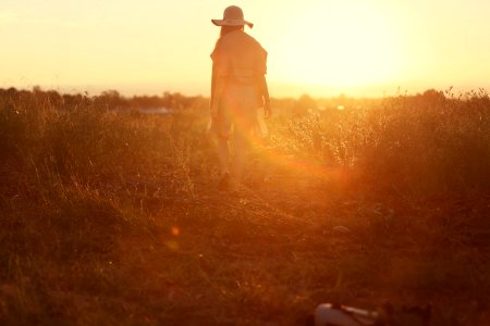 person standing on green grass during sunset photo